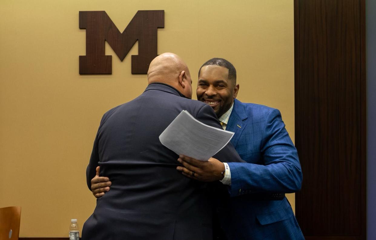 Sherrone Moore, head coach of the University of Michigan football team, hugs Warde Manuel, Michigan’s Director of Athletics, during a press conference inside the Junge Family Champions Center in Ann Arbor on Saturday, Jan. 27, 2024.