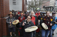 FILE - In this Jan. 6, 2020, file photo, Tony A. (Naschio) Johnson, center, elected chairman of the Chinook Indian Nation, plays a drum as he leads tribal members and supporters as they march to the federal courthouse in Tacoma, Wash., as they continue their efforts to regain federal recognition. As COVID-19 disproportionately affects Native American communities, many tribal leaders say the pandemic poses particular risks to tribes without federal recognition. The Chinook Nation received some federal funding through a local nonprofit for small tribes to distribute food to elders and help with electricity bills, tribal Johnson said. (AP Photo/Ted S. Warren, File)