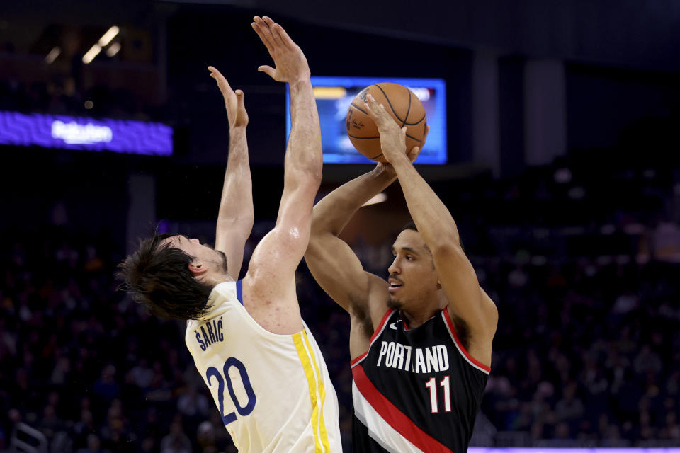 Portland Trail Blazers guard Malcolm Brogdon (11) shoots against Golden State Warriors forward Dario Saric (20) during the first half of an NBA basketball game in San Francisco, Wednesday, Dec. 6, 2023. (AP Photo/Jed Jacobsohn)