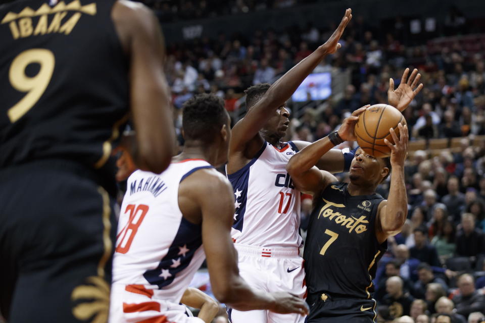 Toronto Raptors guard Kyle Lowry (7) is defended by Washington Wizards guard Isaac Bonga (17) and center Ian Mahinmi (28) during the first half of an NBA basketball game Friday, Jan. 17, 2020, in Toronto. (Cole Burston/The Canadian Press via AP)