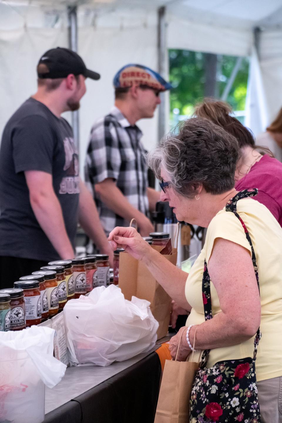 Shoppers peruse various goodies from vendors in the Marketplace Tent at the 2023 Salt Fork Arts & Crafts Festival. Shirley Goodpastor, a Culinary Challenge competitor, had her famous baklava available to purchase in the tent.