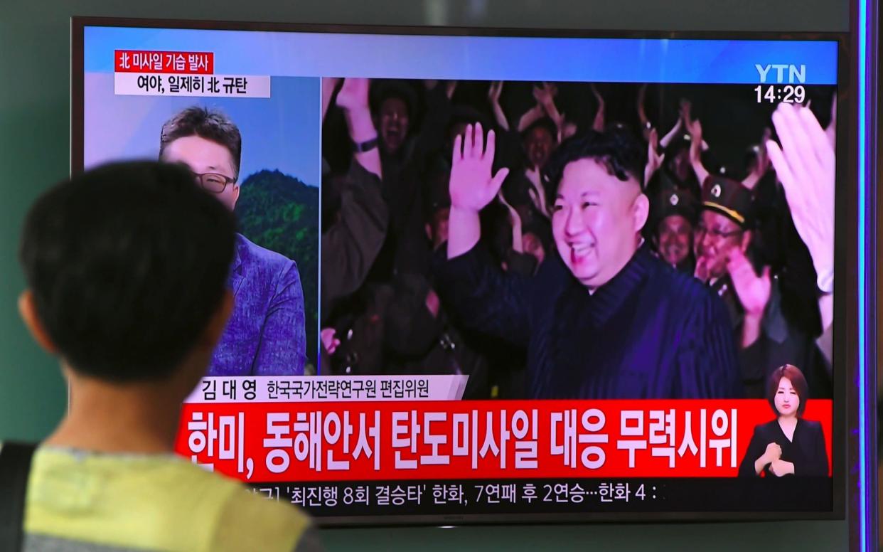 A man watches a television screen showing a video footage of North Korean leader Kim Jong-Un - AFP