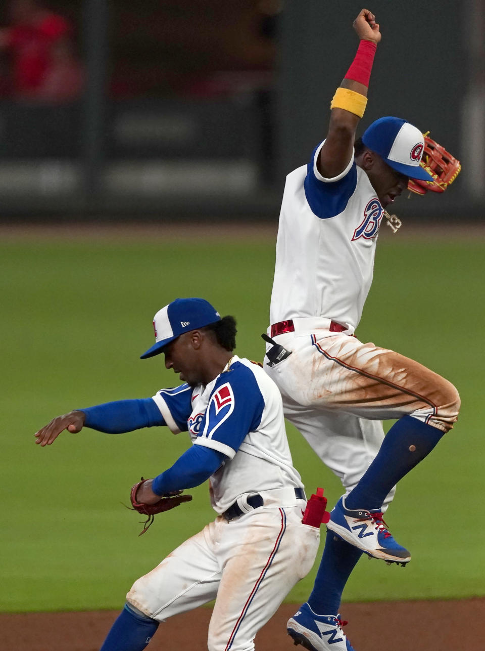 Atlanta Braves Ronald Acuna Jr., right, and Ozzie Albies, left, celebrate after defeating the Philadelphia Phillies in a baseball game Friday, April 9, 2021, in Atlanta. (AP Photo/John Bazemore)