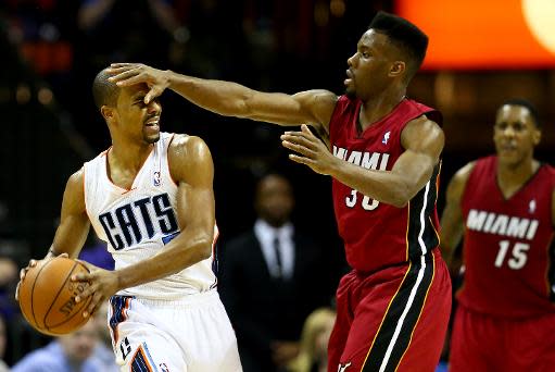 Norris Cole, #30 de Miami Heat, intenta robar el balón a Ramon Sessions, #7 de Charlotte Bobcats, durante duelo de la liga NBA disputado en el Time Warner Cable Arena, el 18 de enero de 2014, en Charlotte, Carolina del Norte. (GETTY IMAGES NORTH AMERICA/AFP | Streeter Lecka)