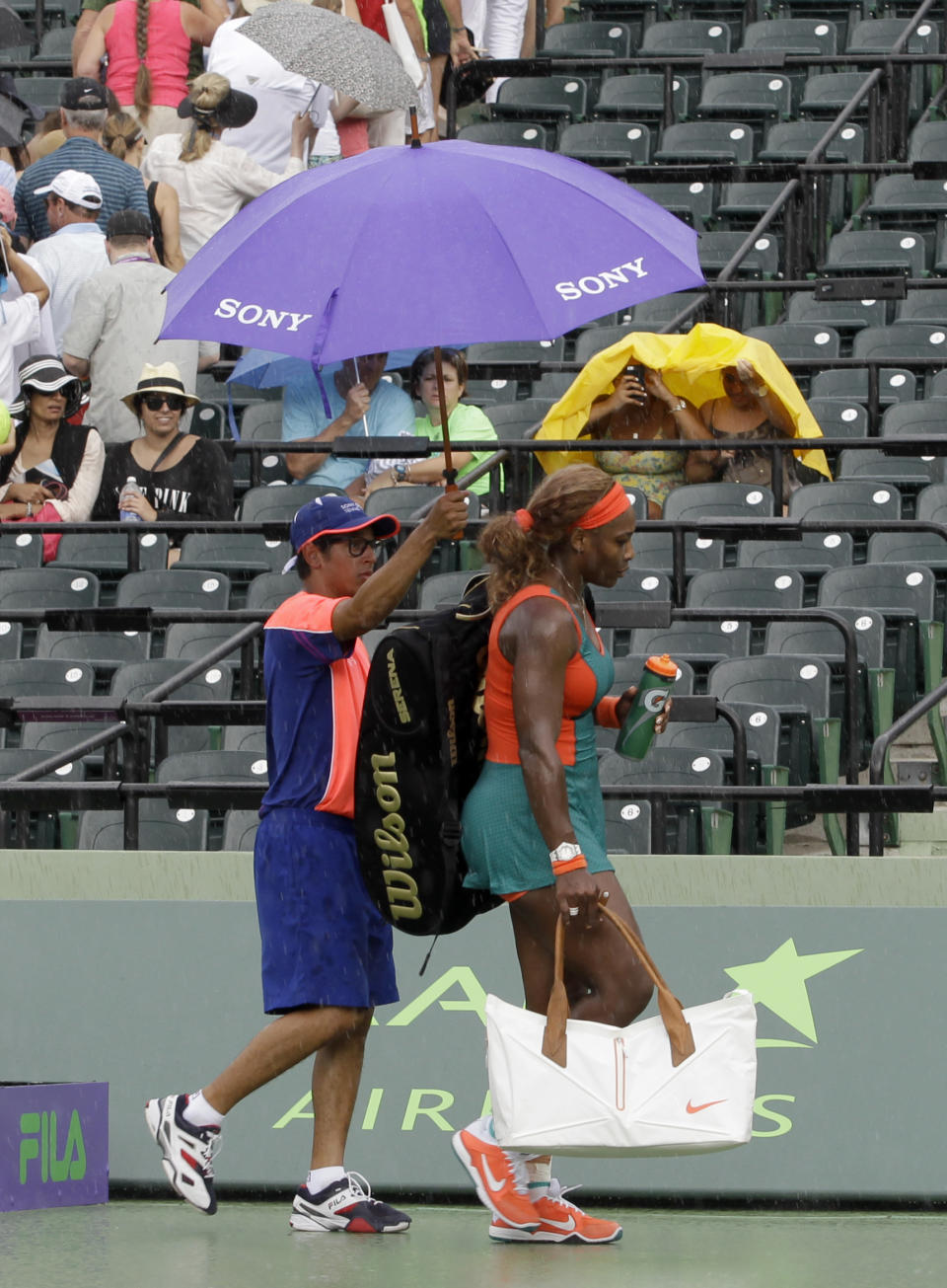 Serena Williams, of the United States, walks off the court as it begins to rain during her match against Caroline Garcia, of France, at the Sony Open tennis tournament in Key Biscayne, Fla., Saturday, March 22, 2014. (AP Photo/Alan Diaz)