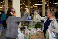 Meir buys produce from Taylor while wearing a mask at the Farmers Public Market in Oklahoma City