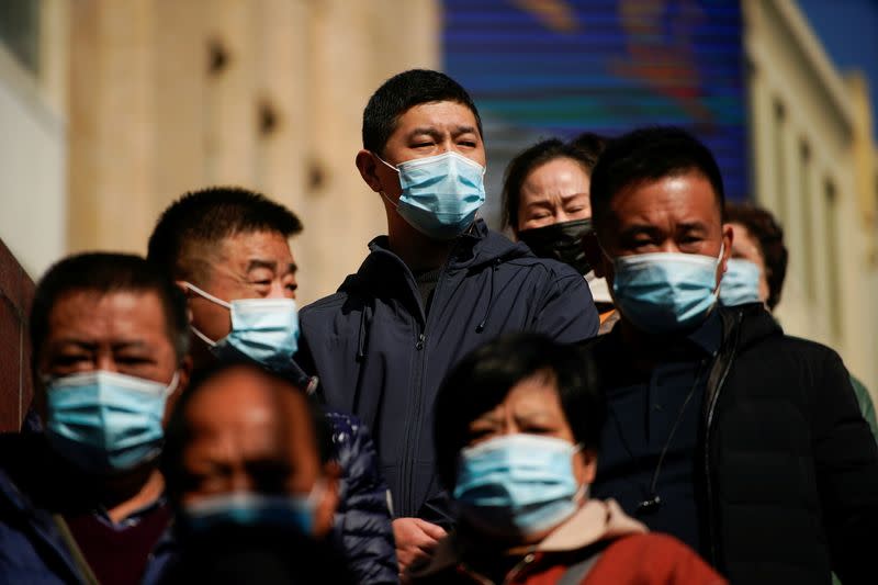 FILE PHOTO: People wearing protective masks are seen on a street