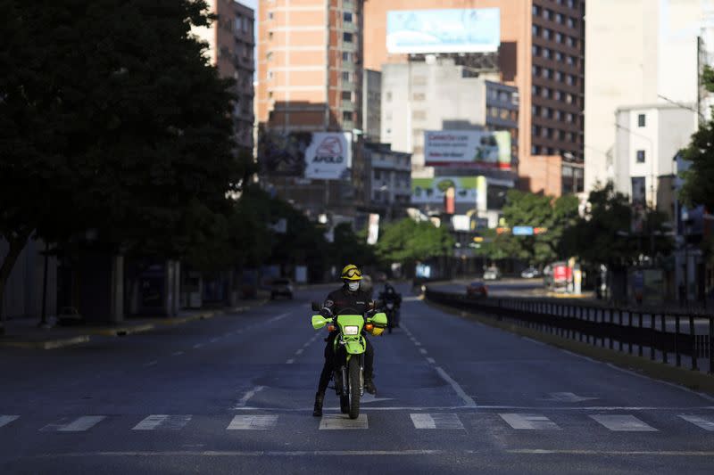 A member of the firefighters rides a motorcycle during the first day of a national quarantine in response to the spreading coronavirus disease (COVID-19), in Caracas