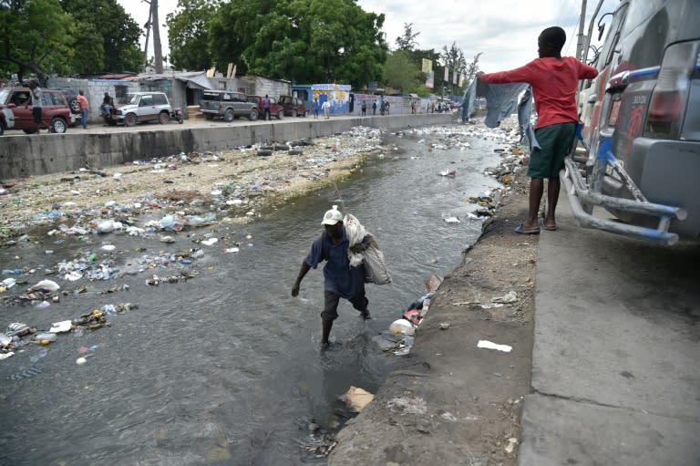 A man collects recyclables in the canal of Portail Leogane, in the Haitian capital Port-au-Prince, on October 1, 2016