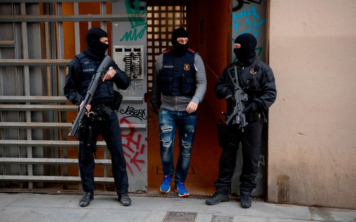 Catalan regional police officers 'Mossos D'Esquadra' stand guard outside a building in Barcelona, during a counter-terrorism operation  - AFP