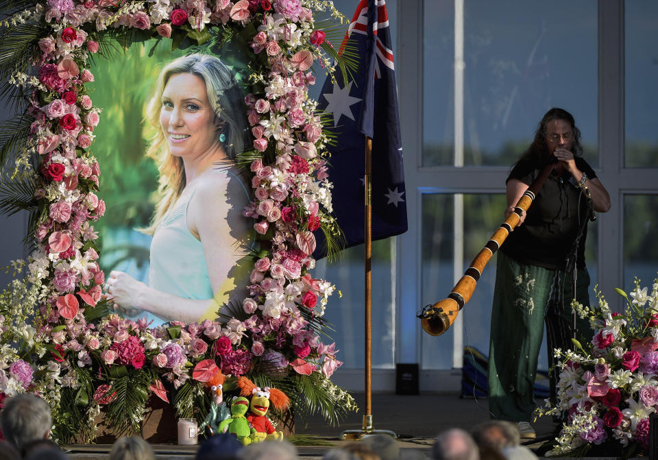 FILE - In this Aug. 11, 2017, file photo, Johanna Morrow plays the didgeridoo during a memorial service for Justine Ruszczyk Damond at Lake Harriet in Minneapolis. Defense attorneys want charges dismissed against a former Minneapolis police officer who shot and killed the Australian woman last year. Attorneys for ex-officer Mohamed Noor argue in motions filed Wednesday, Aug. 15, 2018, that the charges should be dismissed because of prosecutorial misconduct and lack of probable cause. (Aaron Lavinsky /Star Tribune via AP, File)