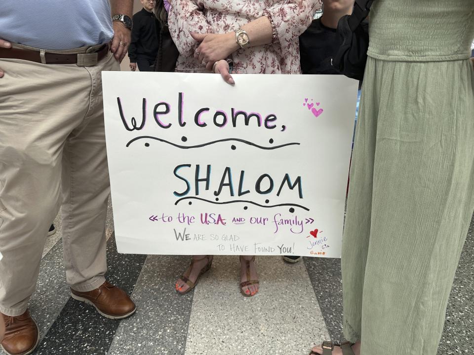 CORRECTS SPELLING TO KORAI NOT KORAY - A family member holds up a sign as they meet Shalom Korai for the first time on Wednesday, July 10, 2024, in North Charleston, S.C. Korai was orphaned during the Holocaust and never knew any of his relatives until a DNA test in 2023. (AP Photo/Jeffrey Collins)