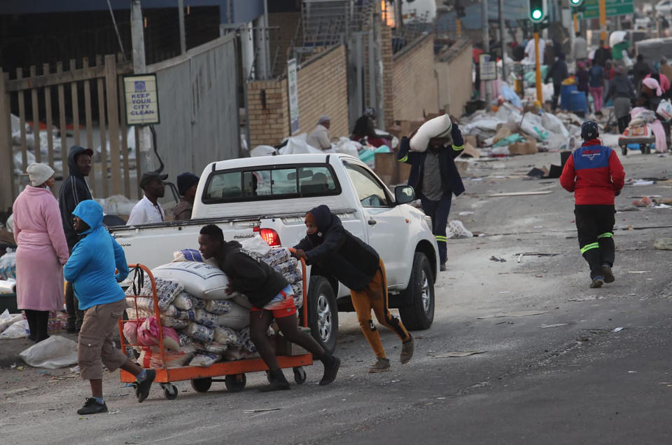 A trolley with bags of rice stolen from a factory in Mobeni, south of Durban South Africa is pushed along a road, Thursday, July 15, 2021, as unrest continued in the KwaZulu Natal province. South African police and the army are struggling to bring order to impoverished areas of South Africa rocked by weeklong unrest and days of looting sparked by the imprisonment last week of ex-President Jacob Zuma. (AP Photo)