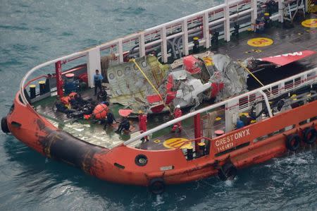 The tail of AirAsia QZ8501 passenger plane is seen on the deck of the Indonesian Search and Rescue (BASARNAS) ship Crest Onyx after it was lifted from the sea bed, in the Java Sea January 10, 2015. REUTERS/Adek Berry/Pool