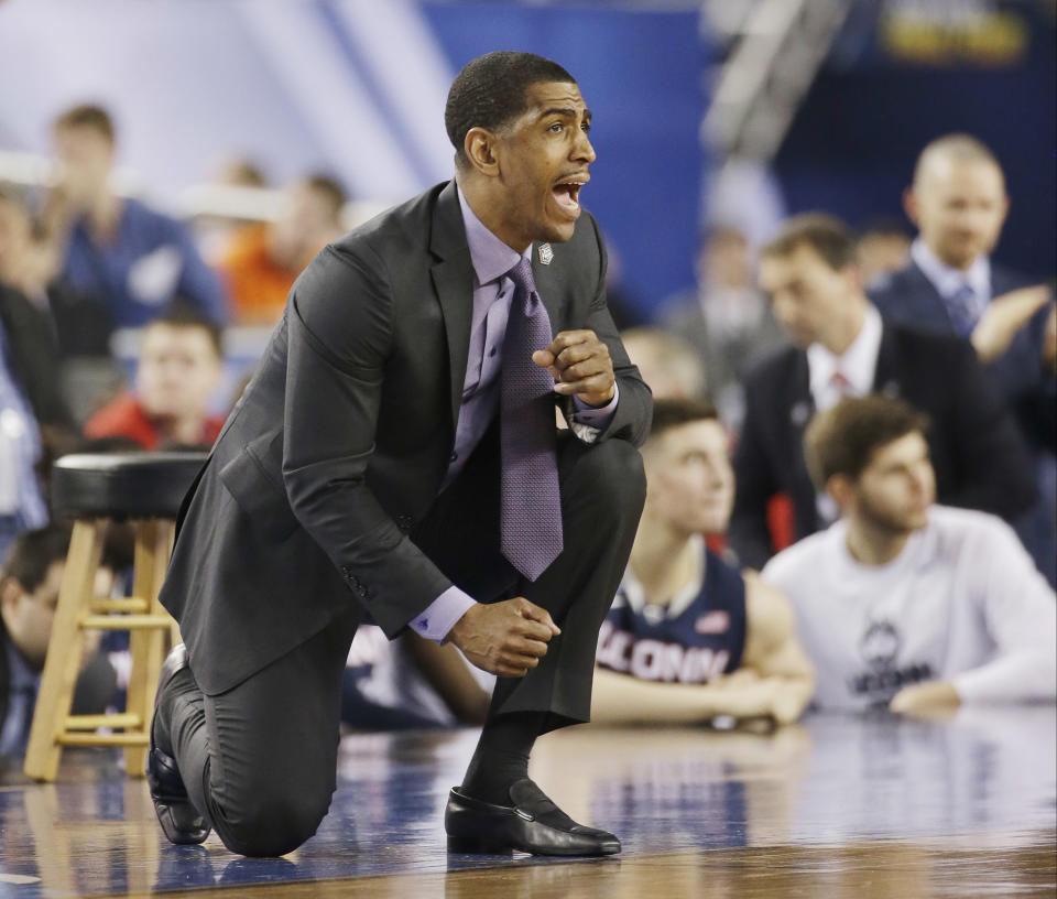 Connecticut head coach Kevin Ollie cheers his team against Florida during the second half of the NCAA Final Four tournament college basketball semifinal game Saturday, April 5, 2014, in Arlington, Texas. Connecticut won 63-53. (AP Photo/David J. Phillip)