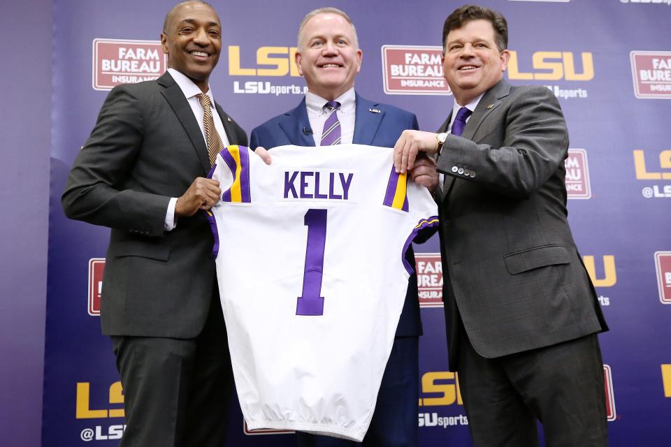 BATON ROUGE, LOUISIANA - DECEMBER 01: Brian Kelly (C) is introduced as the head football coach of the LSU Tigers by LSU President William F. Tate IV (L) and athletics director Scott Woodward during a news conference at Tiger Stadium on December 01, 2021 in Baton Rouge, Louisiana. (Photo by Jonathan Bachman/Getty Images)