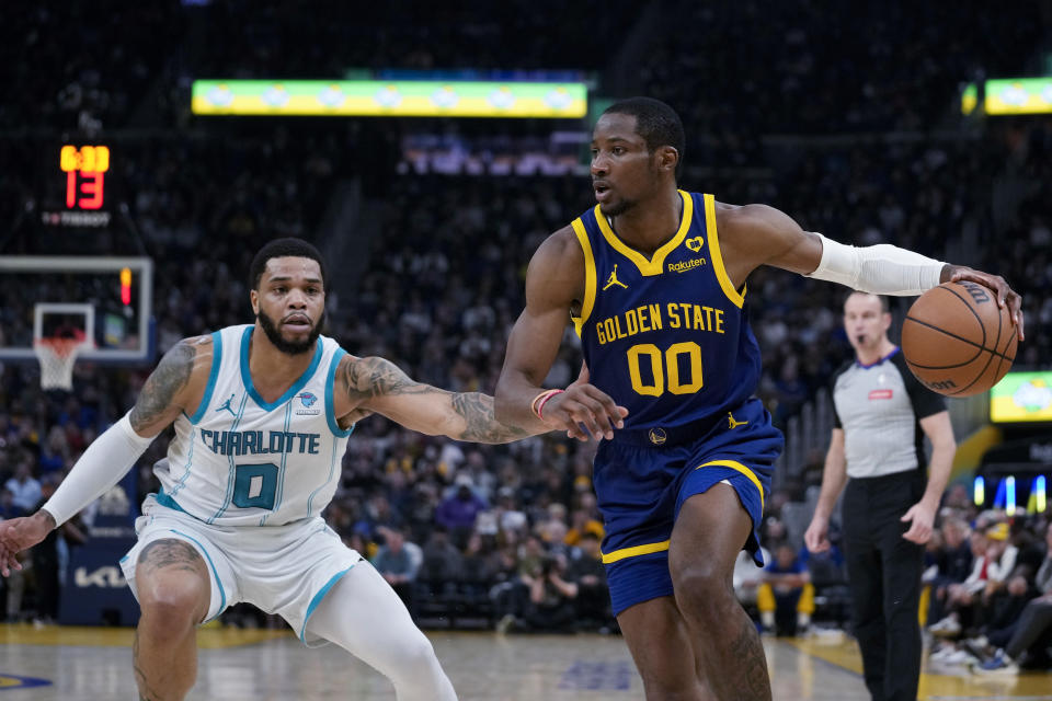 Golden State Warriors forward Jonathan Kuminga, right, is defended by Charlotte Hornets forward Miles Bridges during the first half of an NBA basketball game Friday, Feb. 23, 2024, in San Francisco. (AP Photo/Godofredo A. Vásquez)