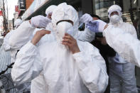 FILE - In this Feb. 27, 2020, file photo, a worker wears a face mask to spray disinfectant as a precaution against the coronavirus at a shopping street in Seoul, South Korea. As the coronavirus spreads around the world, International health authorities are hoping countries can learn a few lessons from China, namely, that quarantines can be effective and acting fast is crucial. On the other hand, the question before the world is to what extent it can and wants to replicate China’s draconian methods. (AP Photo/Ahn Young-joon, File)