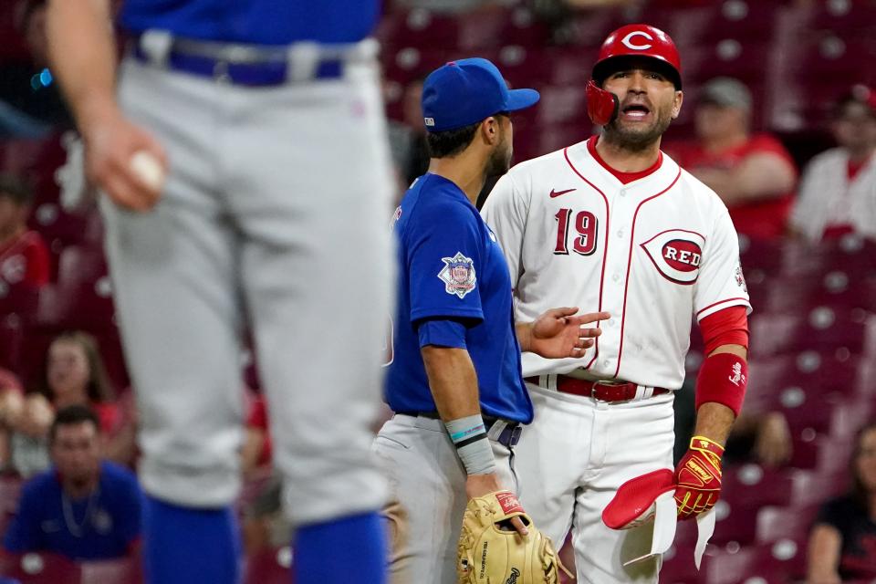 Cincinnati Reds first baseman Joey Votto is restrained by Chicago Cubs first baseman Alfonso Rivas as he argues with pitcher Chicago Cubs relief pitcher Rowan Wick.