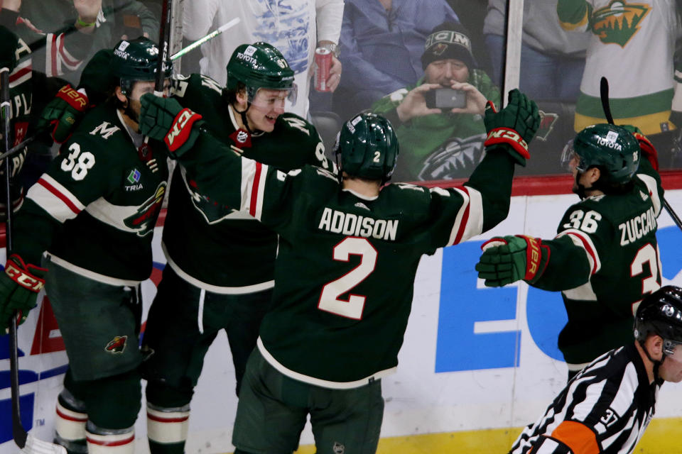 Minnesota Wild left wing Kirill Kaprizov (97) celebrates with Ryan Hartman (38), Calen Addison (2) and Mats Zuccarello (36) after scoring against the Vancouver Canucks in overtime of an NHL hockey game Thursday, Oct. 20, 2022, in St. Paul, Minn. (AP Photo/Andy Clayton-King)