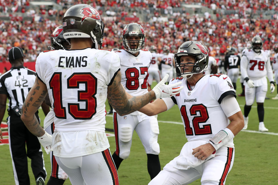 Tampa Bay Buccaneers quarterback Tom Brady (12) celebrates with wide receiver Mike Evans (13) after Evans caught a 3-yard touchdown pass during the first half of an NFL football game Sunday, Sept. 19, 2021, in Tampa, Fla. (AP Photo/Mark LoMoglio)