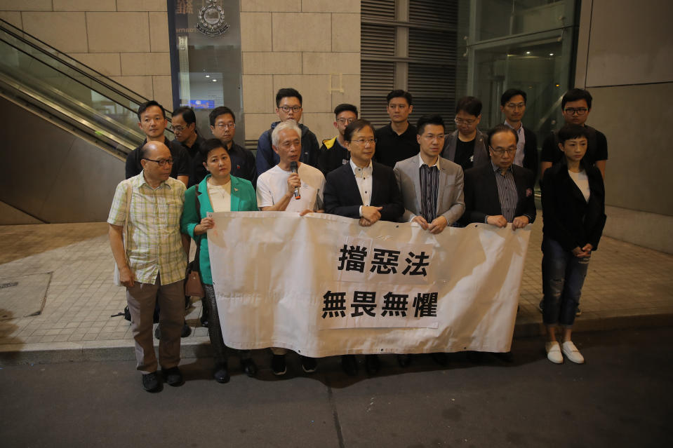 Pro-democracy lawmakers Leung Yiu-chung, third left, Kwok Ka-ki, center, and Gary Fan, third right, protest outside police headquarters against the arrest of their colleagues, holding a banner that reads “defeat the evil law, Fearless” in Hong Kong, Saturday, Nov. 9, 2019. Three members of the Legislative Council of the Hong Kong Special Administrative Region were arrested for allegedly breaching legislative council regulation earlier this year, Hong Kong police confirmed Saturday. The arrests were made over Friday and Saturday after the police carefully investigated reports of obstruction at a meeting in the Legislative Council Complex on May 11, they told Xinhua. (AP Photo/Kin Cheung)