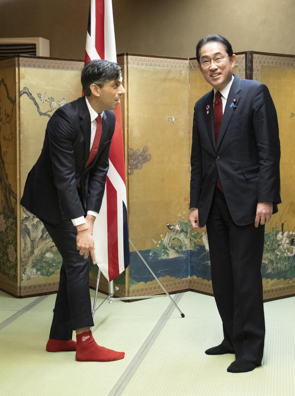 British Prime Minister Rishi Sunak shows off his socks to Japanese Prime Minister Fumio Kishida, which has the name of Kishida's favorite baseball team, Hiroshima Toyo Carp, on them, during their bilateral meeting in Hiroshima ahead of the G7 Summit in Japan, Thursday May 18, 2023. (Stefan Rousseau, Pool via AP)