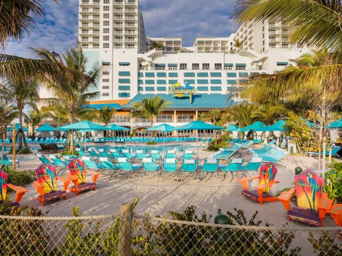 An empty pool and lounge chairs by the Lone Palm Pool in a Margaritaville hotel.