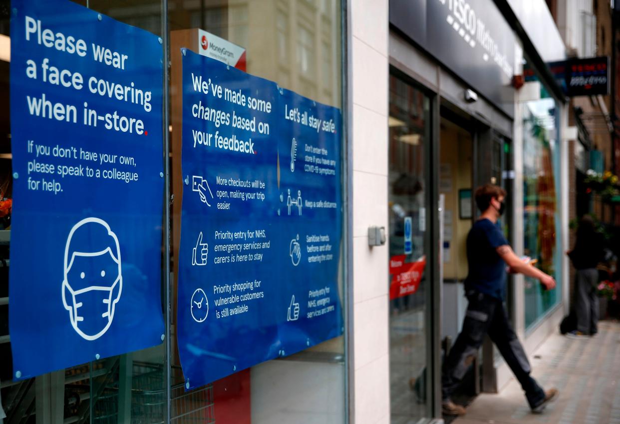 A Tesco store displays requests for shoppers to use face coverings (AFP via Getty Images)