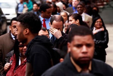 FILE PHOTO -- A man rubs his eyes as he waits in a line of jobseekers, to attend the Dr. Martin Luther King Jr. career fair held by the New York State department of Labor in New York April 12, 2012. REUTERS/Lucas Jackson/File Photo