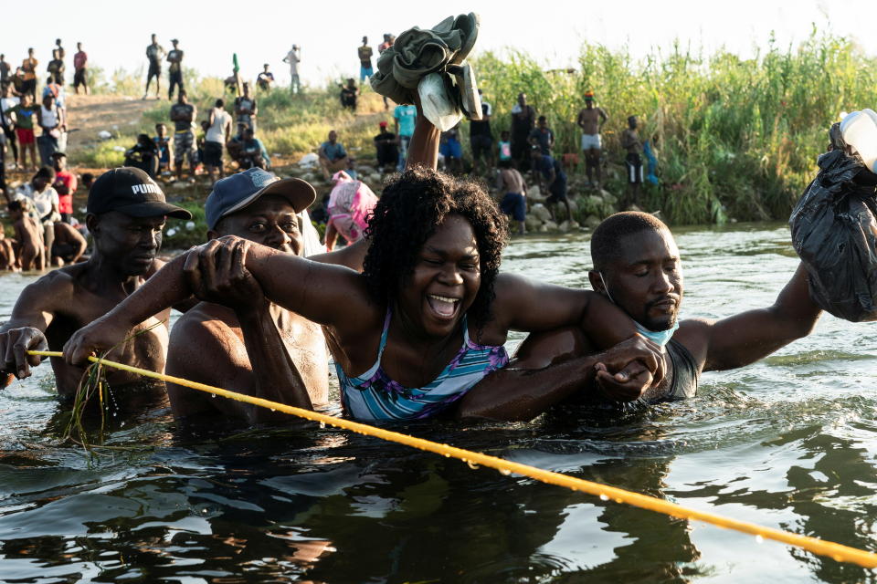 Migrants seeking asylum in the U.S. grab onto a rope to guide them through the current while crossing the Rio Grande river into Mexico near the International Bridge between Mexico and the U.S. in Ciudad Acuna, Mexico, September 20, 2021. REUTERS/Go Nakamura