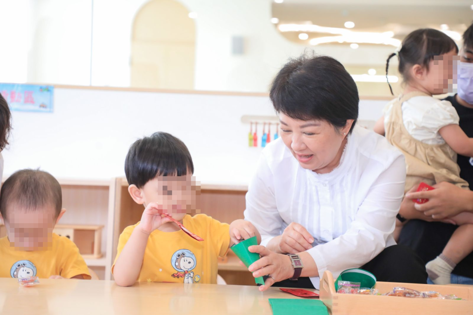 台中市長盧秀燕（右）於6月3日出席石崗公托開幕典禮，與幼兒們溫馨互動。台中市政府提供