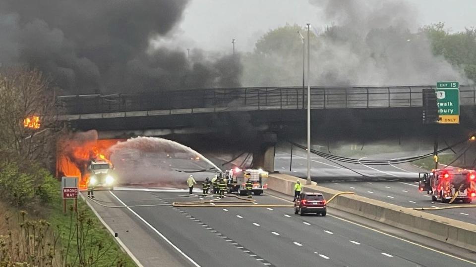 a car on fire on a road with smoke coming out of it