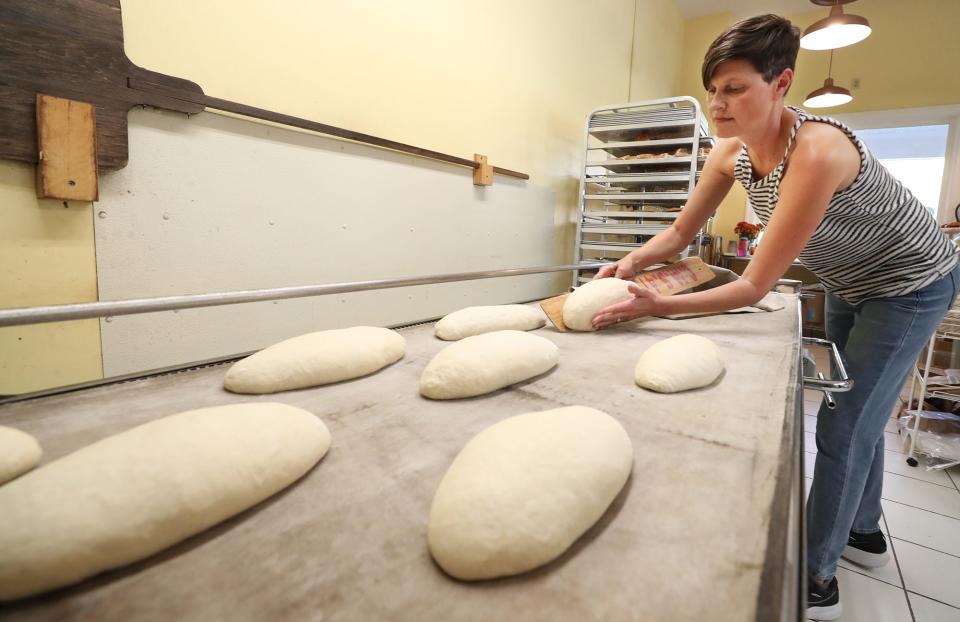 Stacy Siddle, co-owner of Awaken Bake Company in Hudson, prepares to put loaves of French batards in the oven at the bakery.