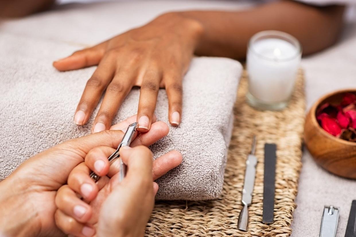 Woman clipping nails at salon