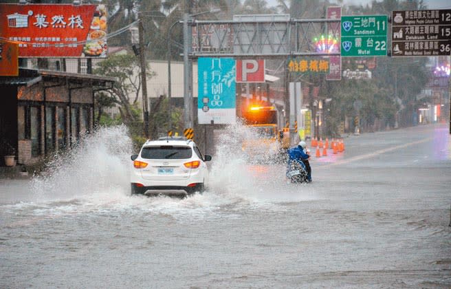 屏東6日豪雨不斷，國道三號長治交流道附近淹水超過半個輪胎，車輛經過濺起大片水花。（林和生攝）
