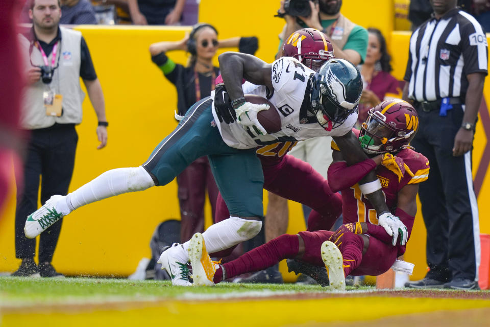 Philadelphia Eagles wide receiver A.J. Brown (11) scoring a touchdown against Washington Commanders safety Jartavius Martin (20) and cornerback Emmanuel Forbes (13) during the second half of an NFL football game, Sunday, Oct. 29, 2023, in Landover, Md. (AP Photo/Alex Brandon)