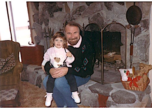 Blair Sharp and her father sitting in front of a fireplace.