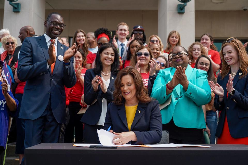 Officials and people in the crowd cheer on Michigan Governor Gretchen Whitmer after she signs into law bills that would allow police officers, family members and medical professionals to ask courts to issue an extreme risk protection order to temporarily take away guns from those who pose a danger to themselves or others on Monday, May 22, 2023, outside of the 44th District Court in Royal Oak.