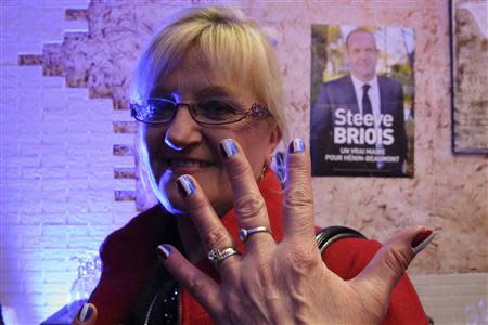 Martine, a 54-year-old France's far-right National Front political party political activist, shows her nails painted with the French national flag at the FN headquarters in Henin Beaumont, Northern France, March 23, 2014. REUTERS/Pascal Rossignol