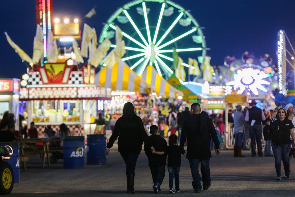 A family walks in the carnival during the San Angelo Stock Show & Rodeo Thursday, Feb. 14, 2019, at the fairgrounds.