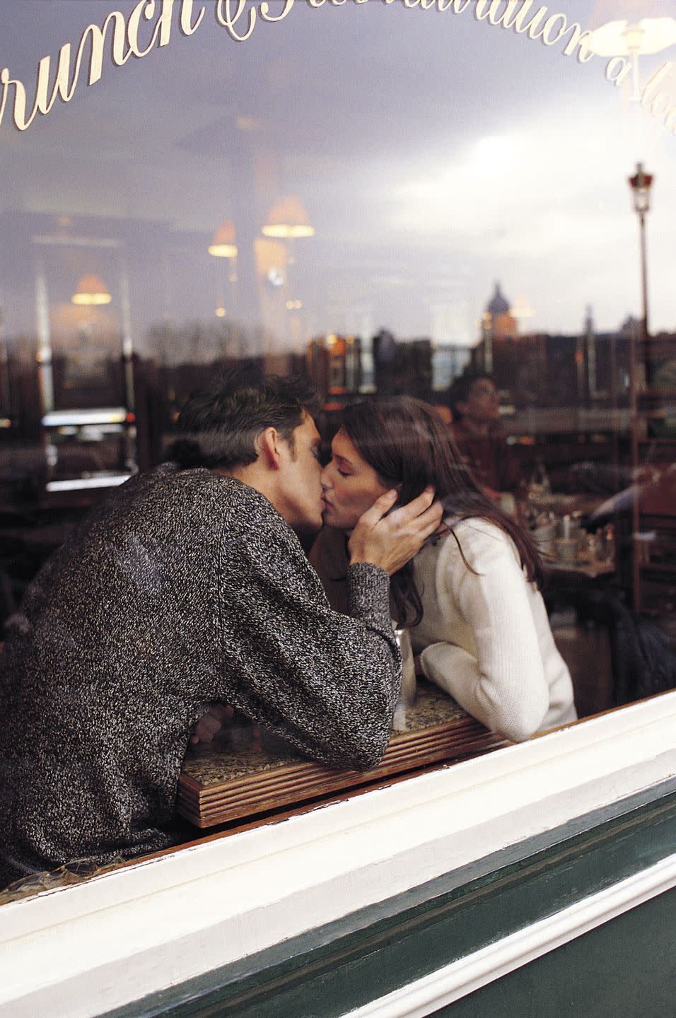 couple kissing in restaurant window