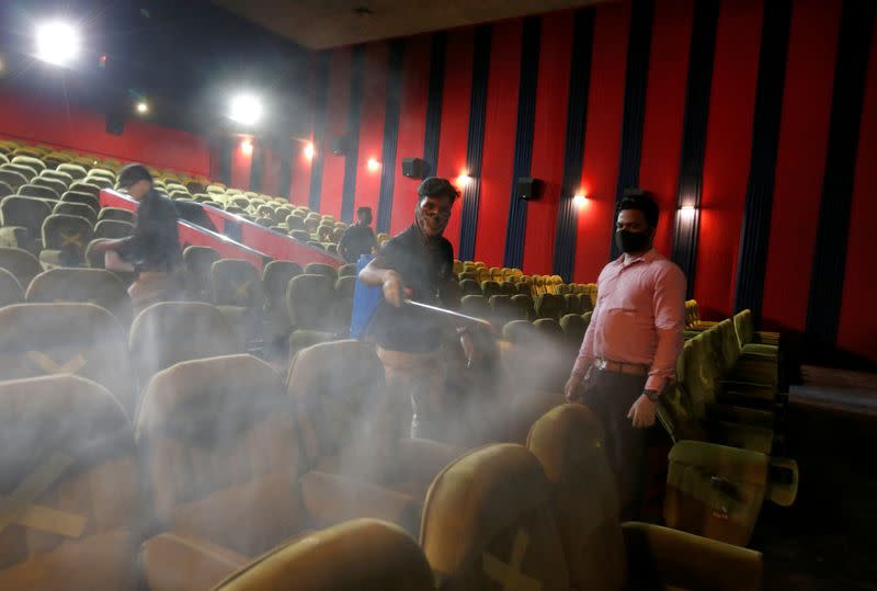 Workers sanitize a hall in City Gold cinema after its reopening in Ahmedabad
