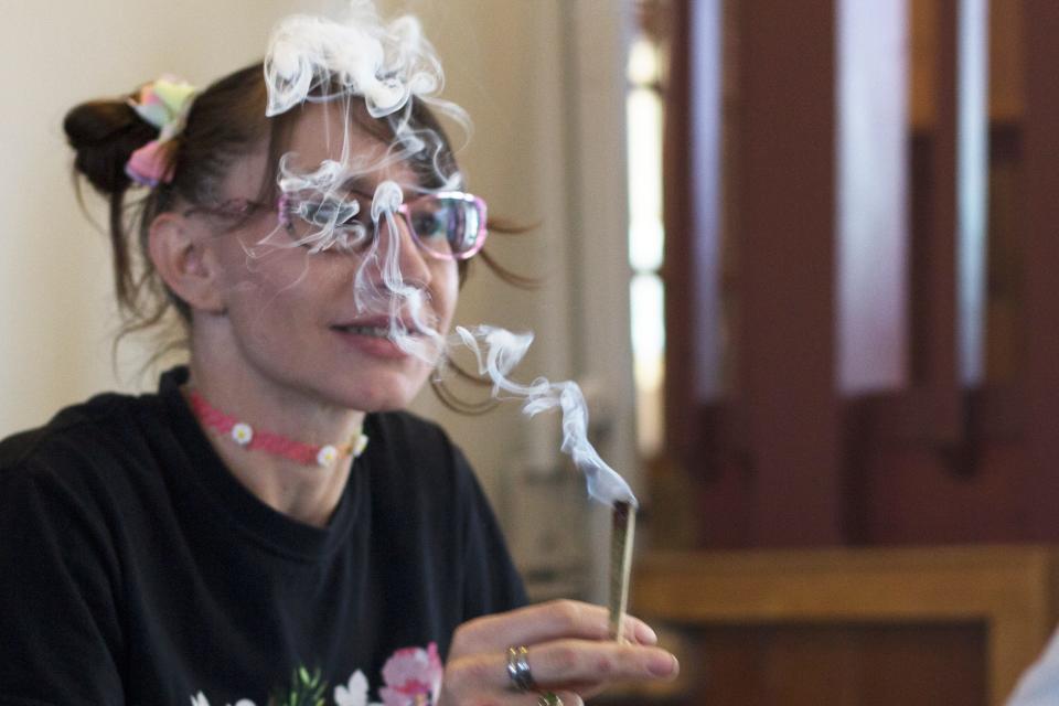 Christina Armstrong smokes while talking to a friend at Sol Cannabis, the first and only cannabis consumption lounge in the state of New Mexico, on April 20, 2022.