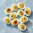 <p>Top these classic <a href="https://www.goodhousekeeping.com/food-recipes/easy/g606/deviled-eggs-recipes/" rel="nofollow noopener" target="_blank" data-ylk="slk:deviled eggs;elm:context_link;itc:0;sec:content-canvas" class="link ">deviled eggs</a> with your favorite flavors — we like bacon, scallions and chives.</p><p>Get the <strong><a href="https://www.goodhousekeeping.com/food-recipes/a48179/best-deviled-eggs-recipe/" rel="nofollow noopener" target="_blank" data-ylk="slk:Easy Deviled Eggs recipe;elm:context_link;itc:0;sec:content-canvas" class="link ">Easy Deviled Eggs recipe</a>.</strong></p>