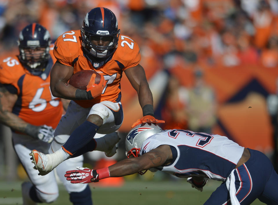 Denver Broncos running back Knowshon Moreno (27) leaps over New England Patriots strong safety Duron Harmon (30) during the first half of the AFC Championship NFL playoff football game in Denver, Sunday, Jan. 19, 2014. (AP Photo/Jack Dempsey)