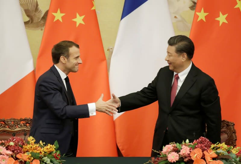 French President Emmanuel Macron shakes hands with China's President Xi Jinping after a joint news conference in Beijing