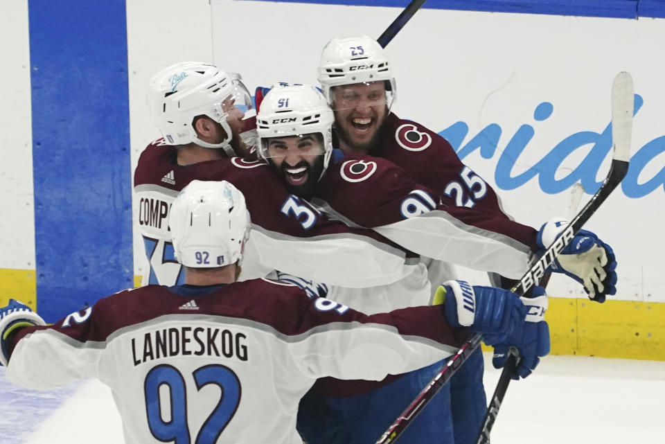 Colorado Avalanche center Nazem Kadri (91) is congratulated by teammates after his overtime goal on Tampa Bay Lightning goaltender Andrei Vasilevskiy (88) in Game 4 of the NHL hockey Stanley Cup Finals on Wednesday, June 22, 2022, in Tampa, Fla. (AP Photo/John Bazemore)