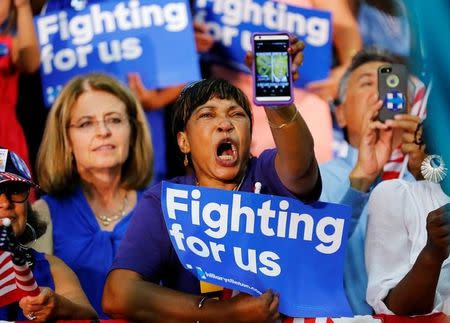 A Hillary supporter yells out with a picture of Donald Trump on her phone as U.S. Democratic presidential candidate Hillary Clinton speaks during a campaign stop in Fresno, California, United States June 4, 2016. REUTERS/Mike Blake