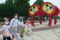 Visitors walk around the Disneyland theme park in Shanghai, China, Monday, May 11, 2020. Visitors wearing face masks streamed into Shanghai Disneyland as China’s most prominent theme park reopened Monday in a new step toward rolling back anti-coronavirus controls that shut down its economy. (AP Photo/Sam McNeil)